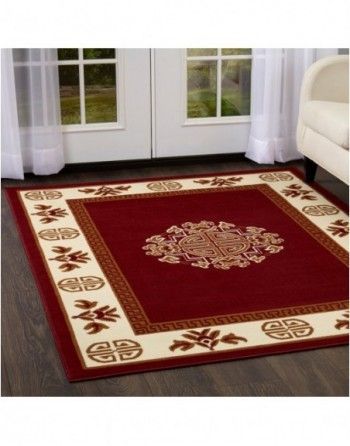 A living room with a red rug and a white couch