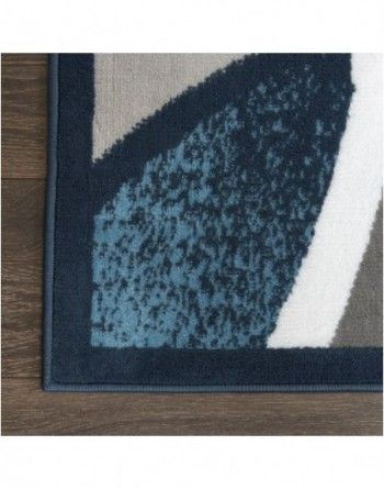A rug with a blue border is on a wooden floor.