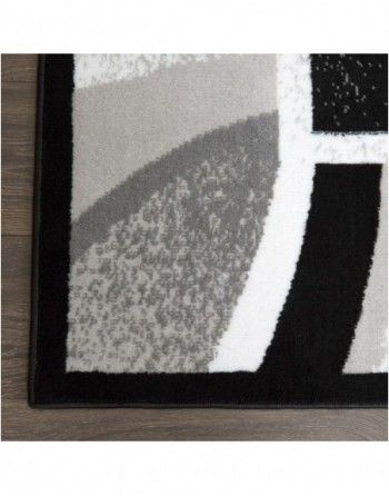 A black and white rug is sitting on a wooden floor.