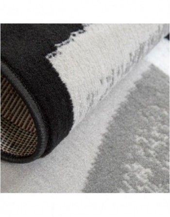 A close up of a black and white rug on a white surface.