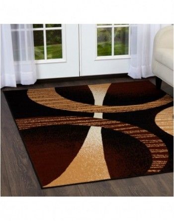 A brown and tan rug in a living room next to a couch