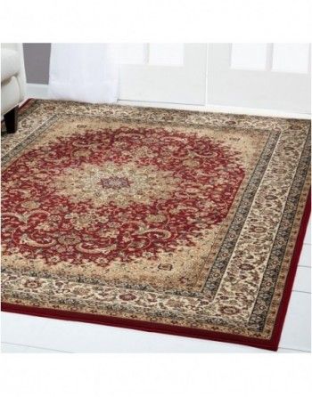 A red and gold rug is on the floor in a living room.