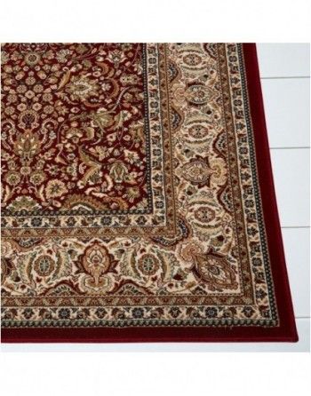 A red and gold rug with a floral pattern on it