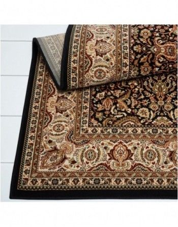 A rug with a black border is laying on a white table.