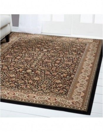 A rug is sitting on the floor in a living room next to a couch.