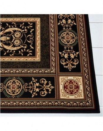 A black and gold rug with a floral design on it