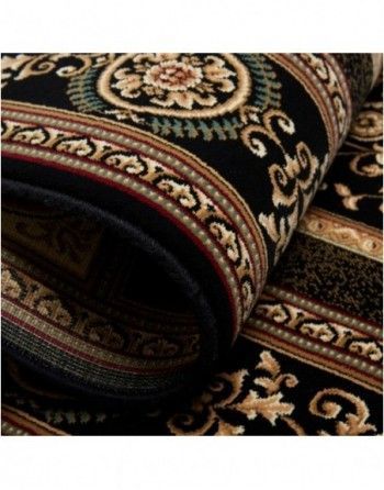 A black and gold rug with a floral pattern