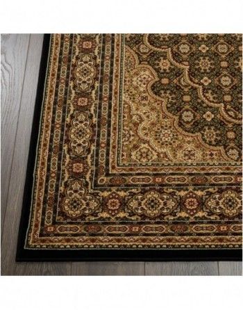 A black and gold rug is sitting on a wooden floor.