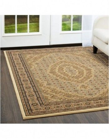 A rug is sitting on a wooden floor in a living room next to a couch.