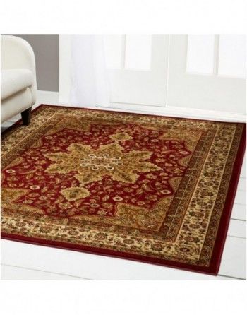 A red and gold rug is sitting on a white floor in a living room.