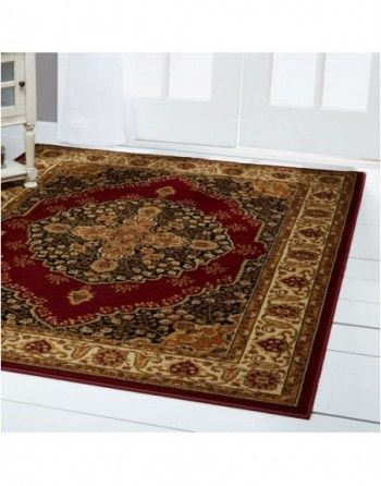A red and gold rug is sitting on a white floor.