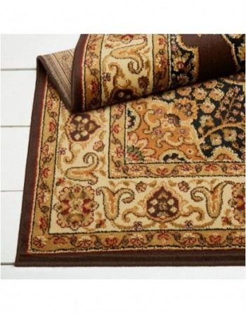 A rug with a floral pattern is rolled up on a table.