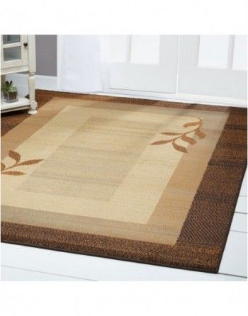 A rug with a brown border and leaves on it