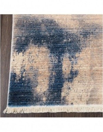 A close up of a blue and beige rug on a wooden floor.
