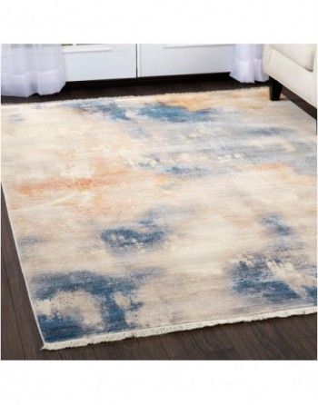 A rug is sitting on a wooden floor next to a couch.