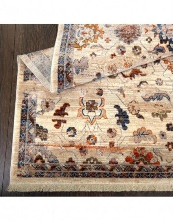 A rug with a floral pattern is laying on a wooden floor.