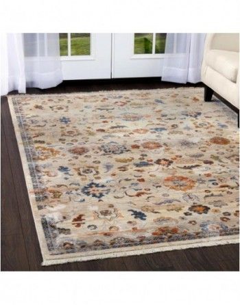 A rug is sitting on a wooden floor in a living room next to a couch.