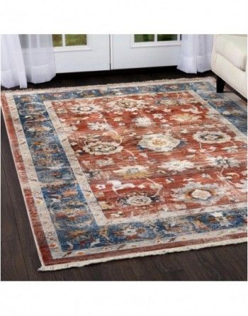 A rug is sitting on a wooden floor in a living room next to a couch.