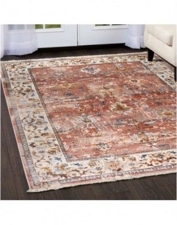 A rug is sitting on a wooden floor in a living room next to a couch.