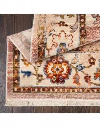 A rug with a floral pattern is laying on a wooden floor.