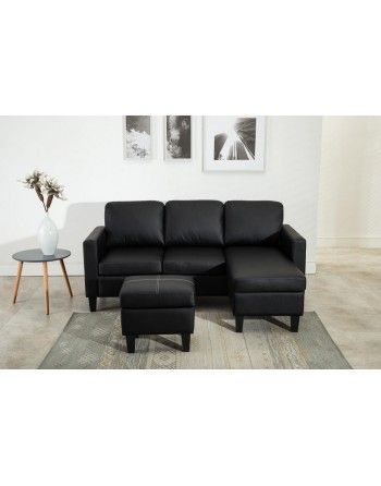 A black leather sectional couch with a chaise lounge and ottoman in a living room.