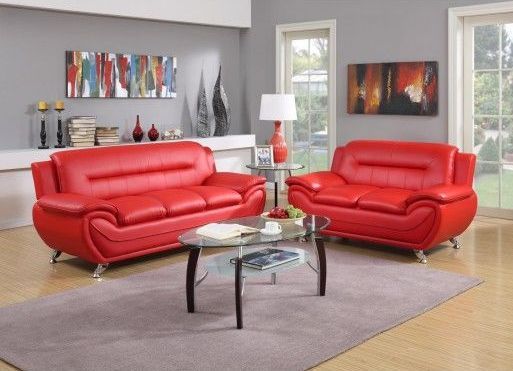 A living room with two red couches and a coffee table