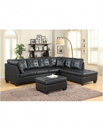 A living room with a black sectional couch and ottoman.