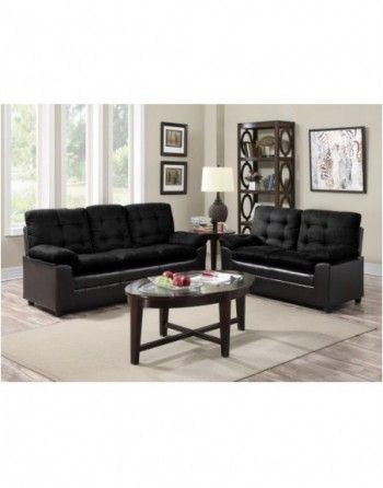A living room with two black couches and a coffee table
