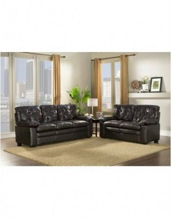 A living room with two black leather couches and a rug.