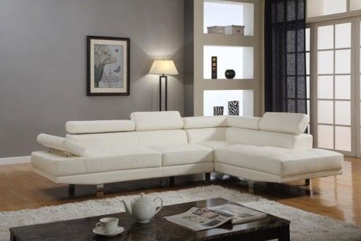 A living room with a white sectional couch and a coffee table