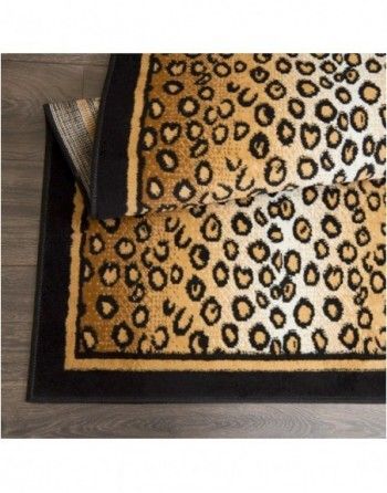 A leopard print rug with a black border is on a wooden floor.