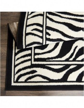 A black and white zebra print rug is on a wooden floor.
