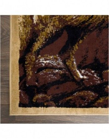 A close up of a brown and gold rug on a wooden floor.