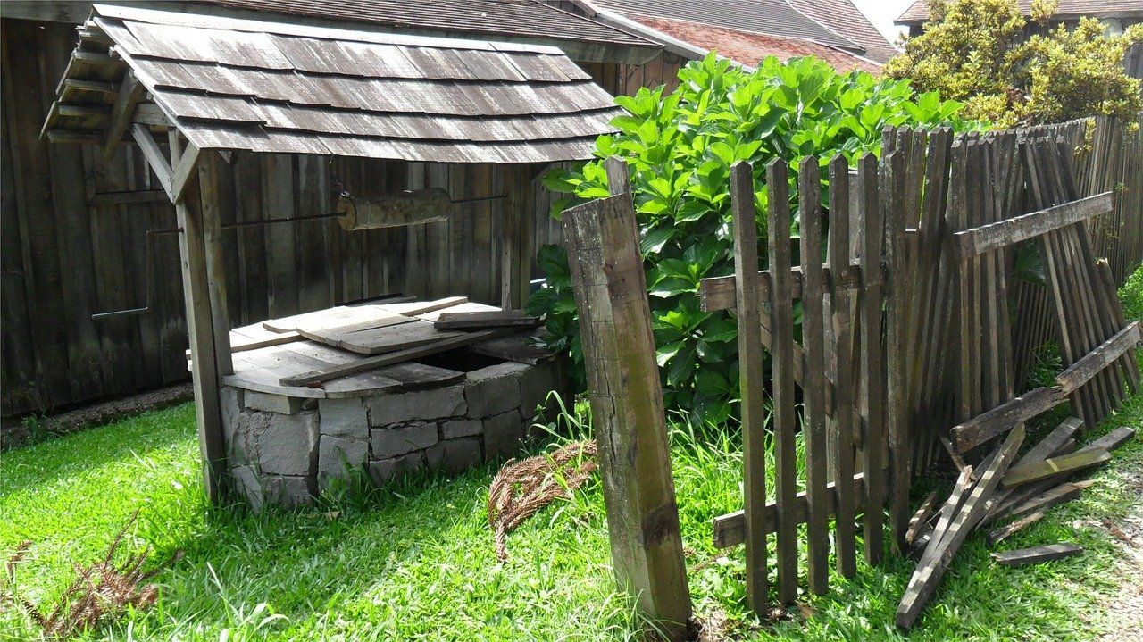 rustic wooden well next to barn