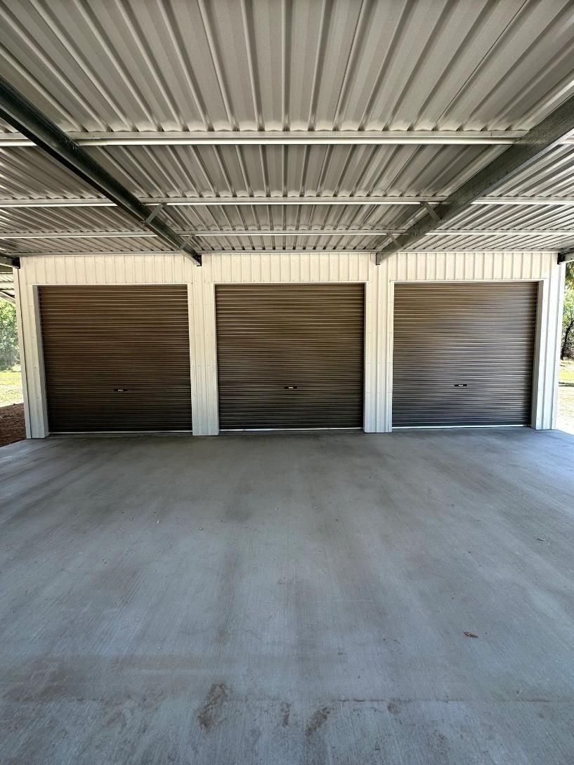 A Garage With Three Garage Doors And A Concrete Floor — Mick’s Garage Doors In Alice River, QLD