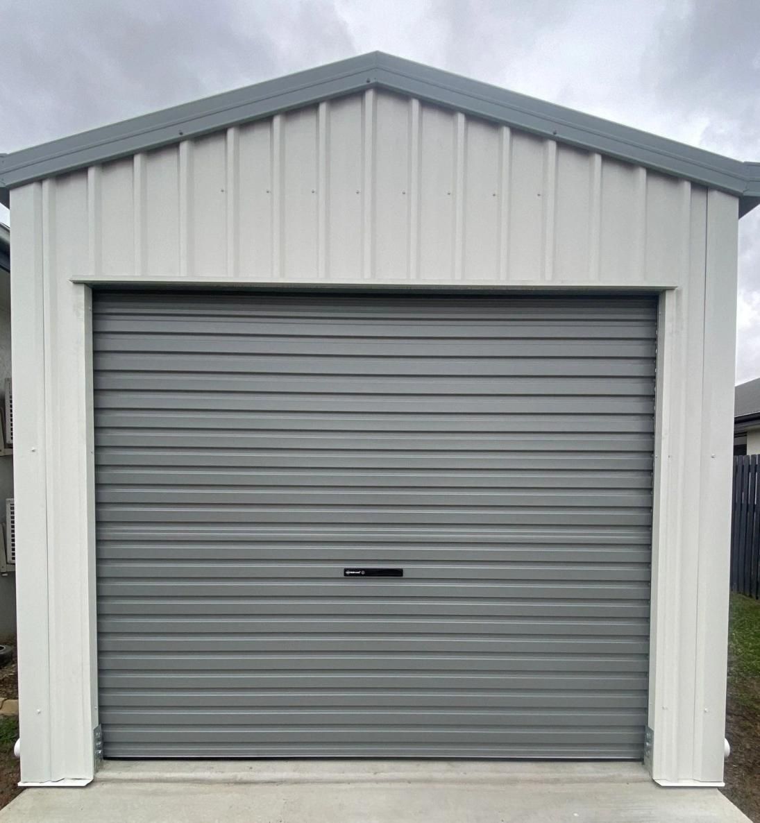A Garage With A Gray Garage Door And A White Roof — Mick’s Garage Doors In Alice River, QLD