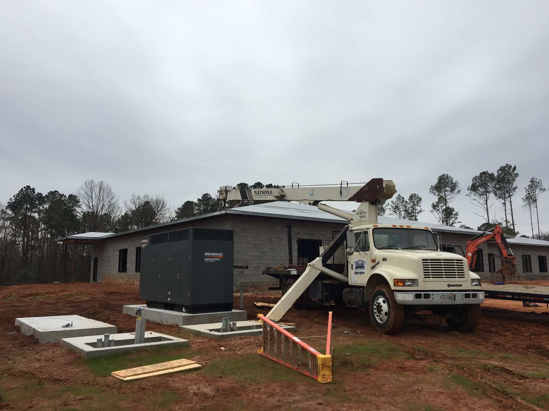 A construction truck is parked in front of a building under construction.