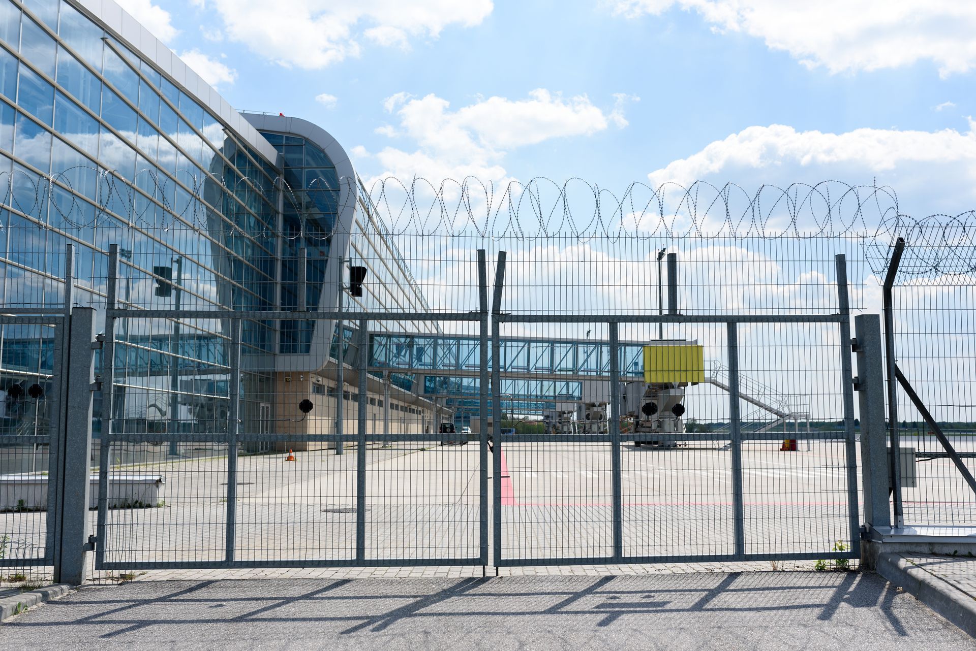 Airport fence grille on the background of passenger bridges for boarding passengers. Airport fence grille on the background of passenger bridges for boarding passengers.