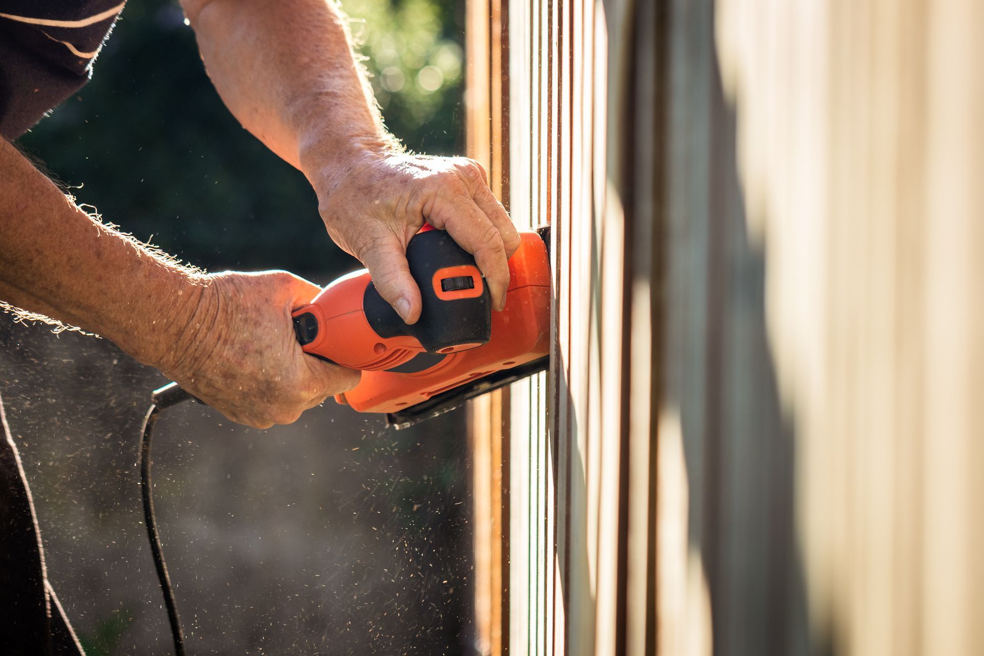 A man is installing a wooden fence.