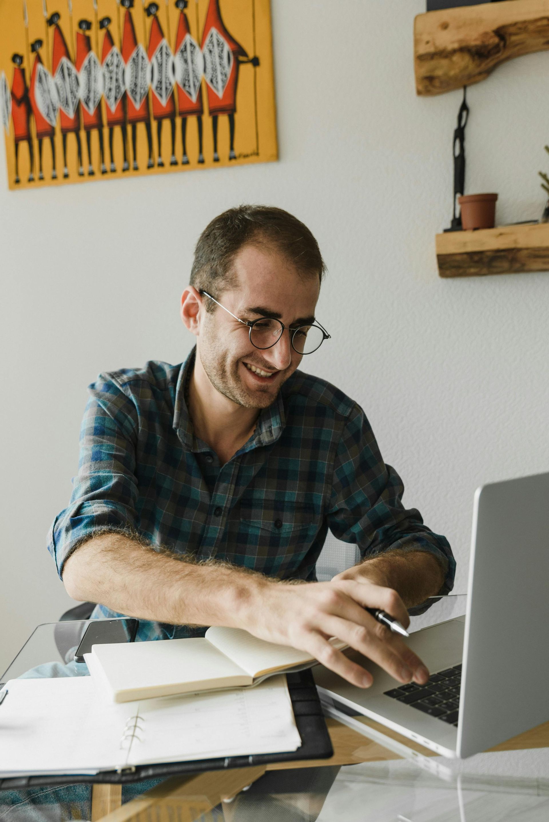 A man is sitting at a desk using a laptop computer.