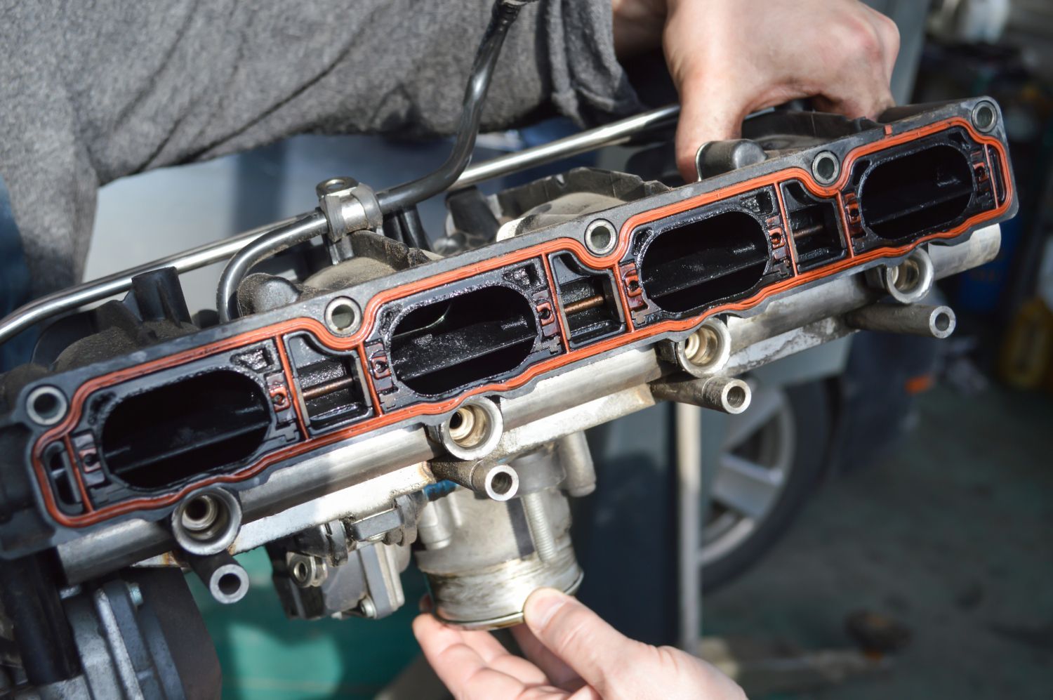 a person is working on a car engine in a garage