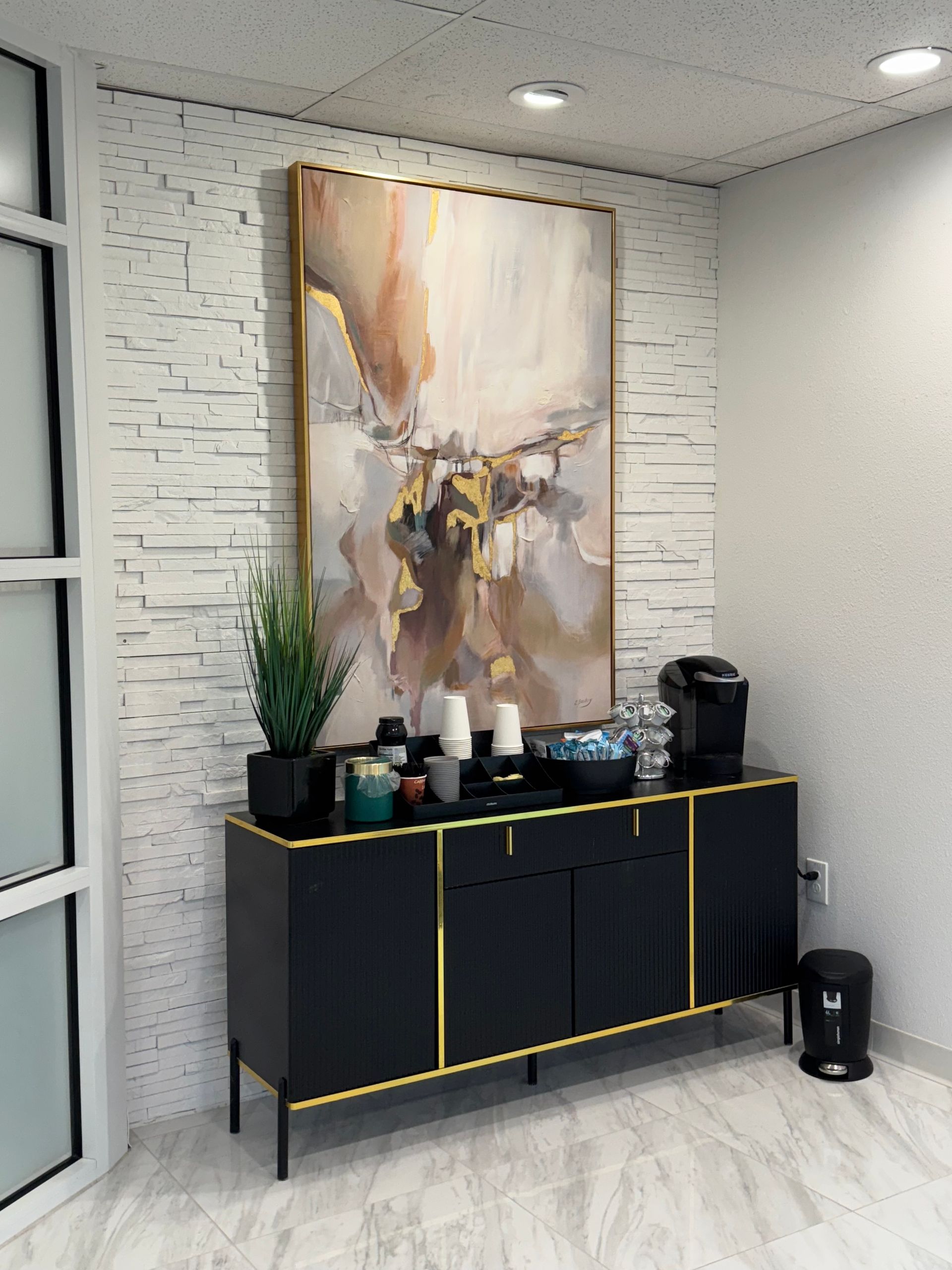 A room with a black dresser and a large painting on the wall