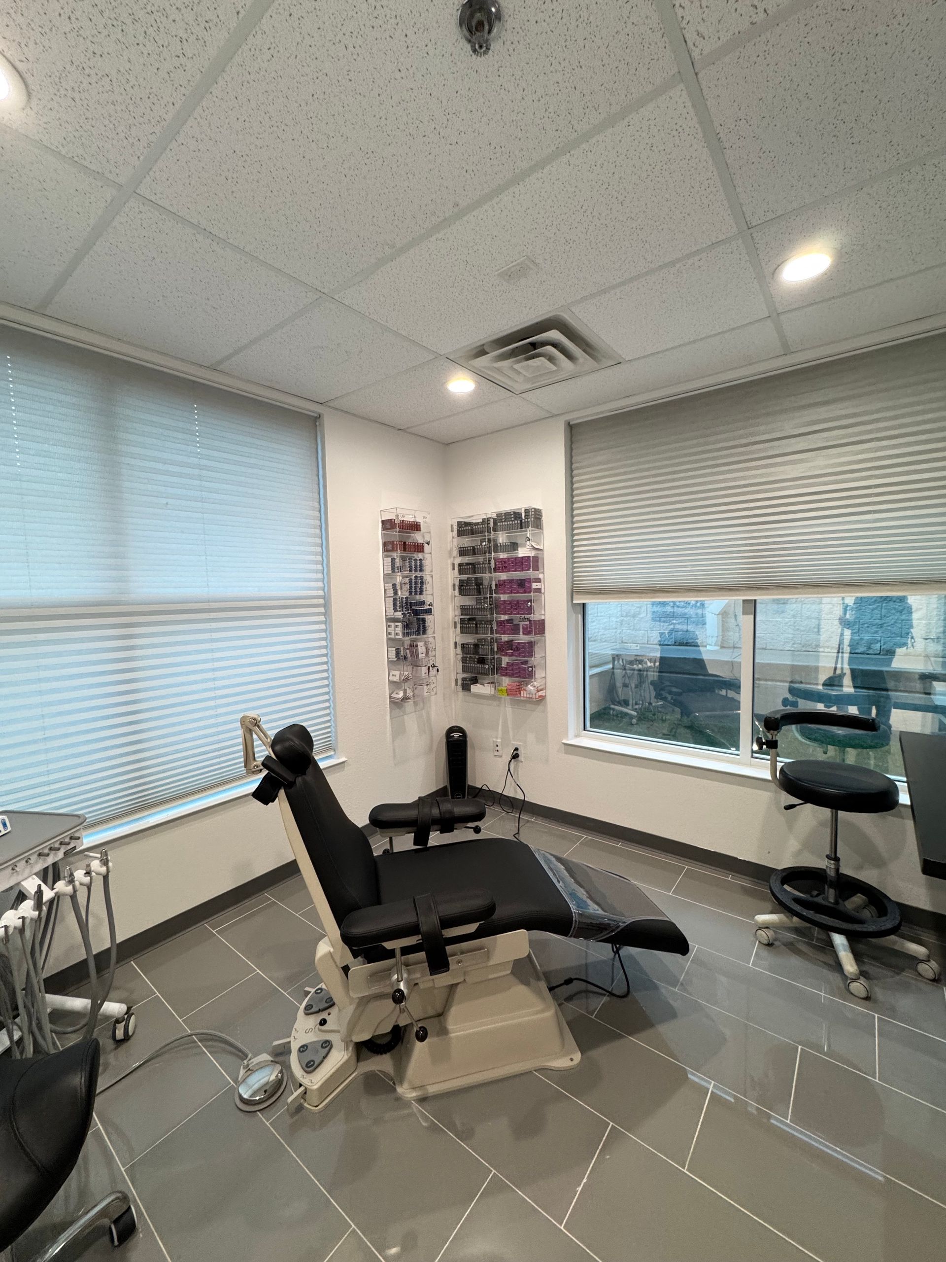 A dental office with a dental chair and a window.