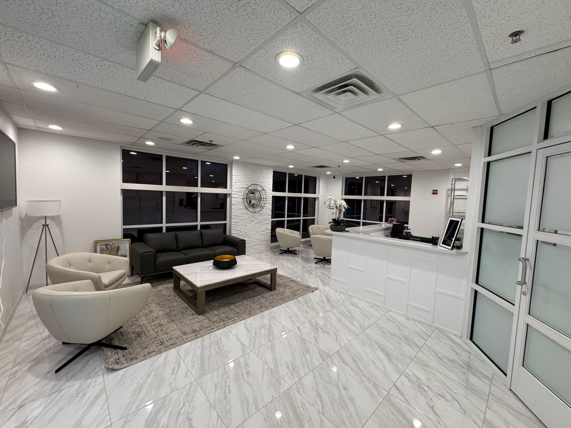 A living room with a couch , chairs , and a coffee table.