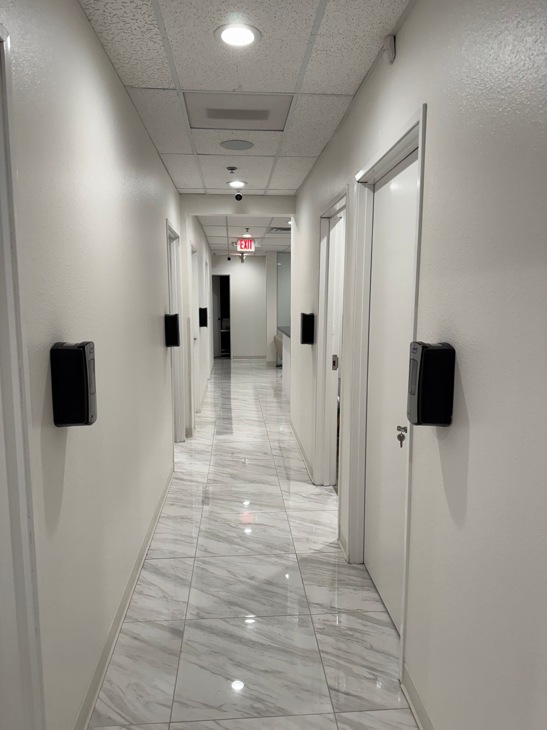 A long hallway with marble floors and white walls