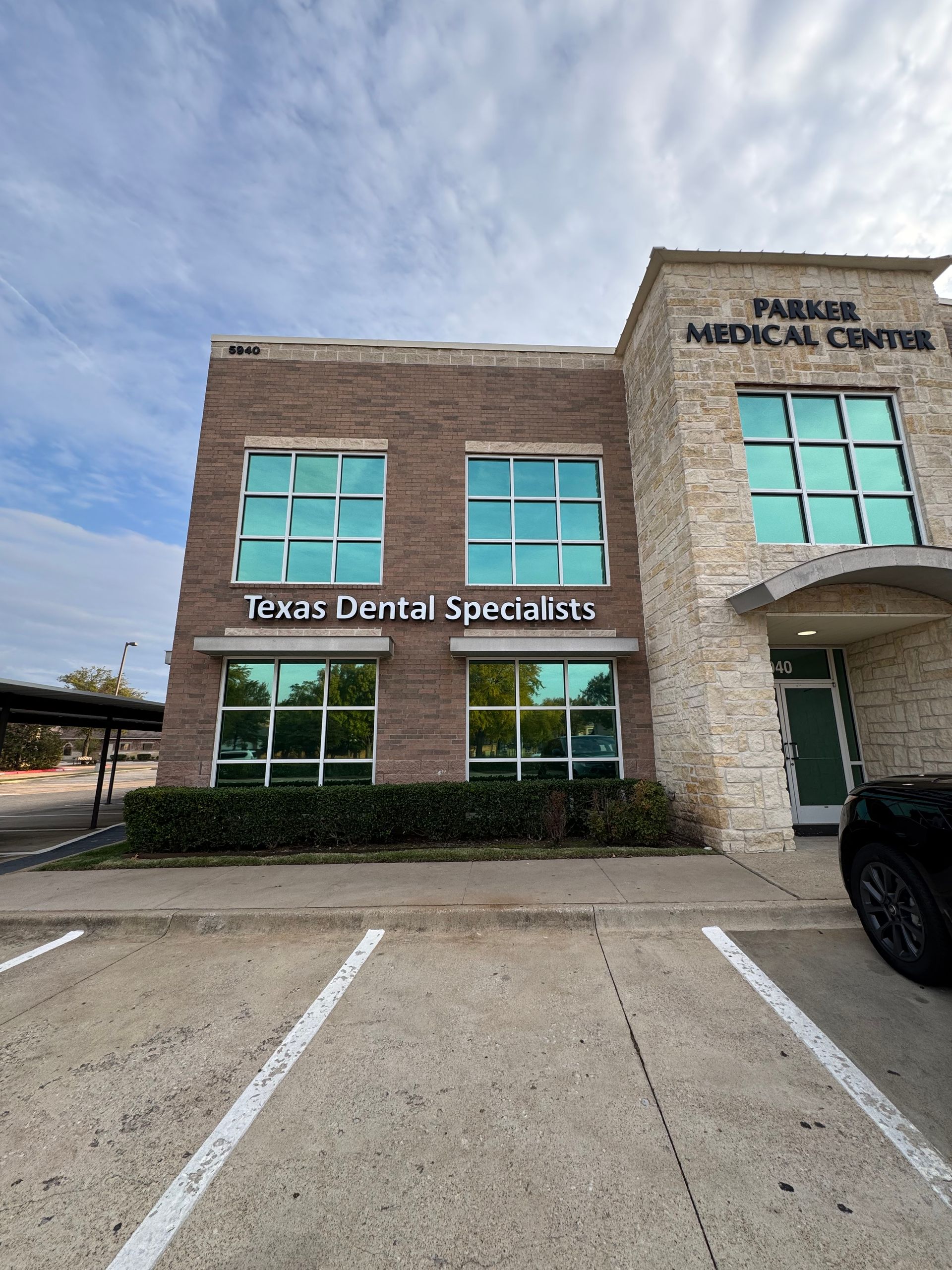 A texas dental specialists building with a parking lot in front of it.