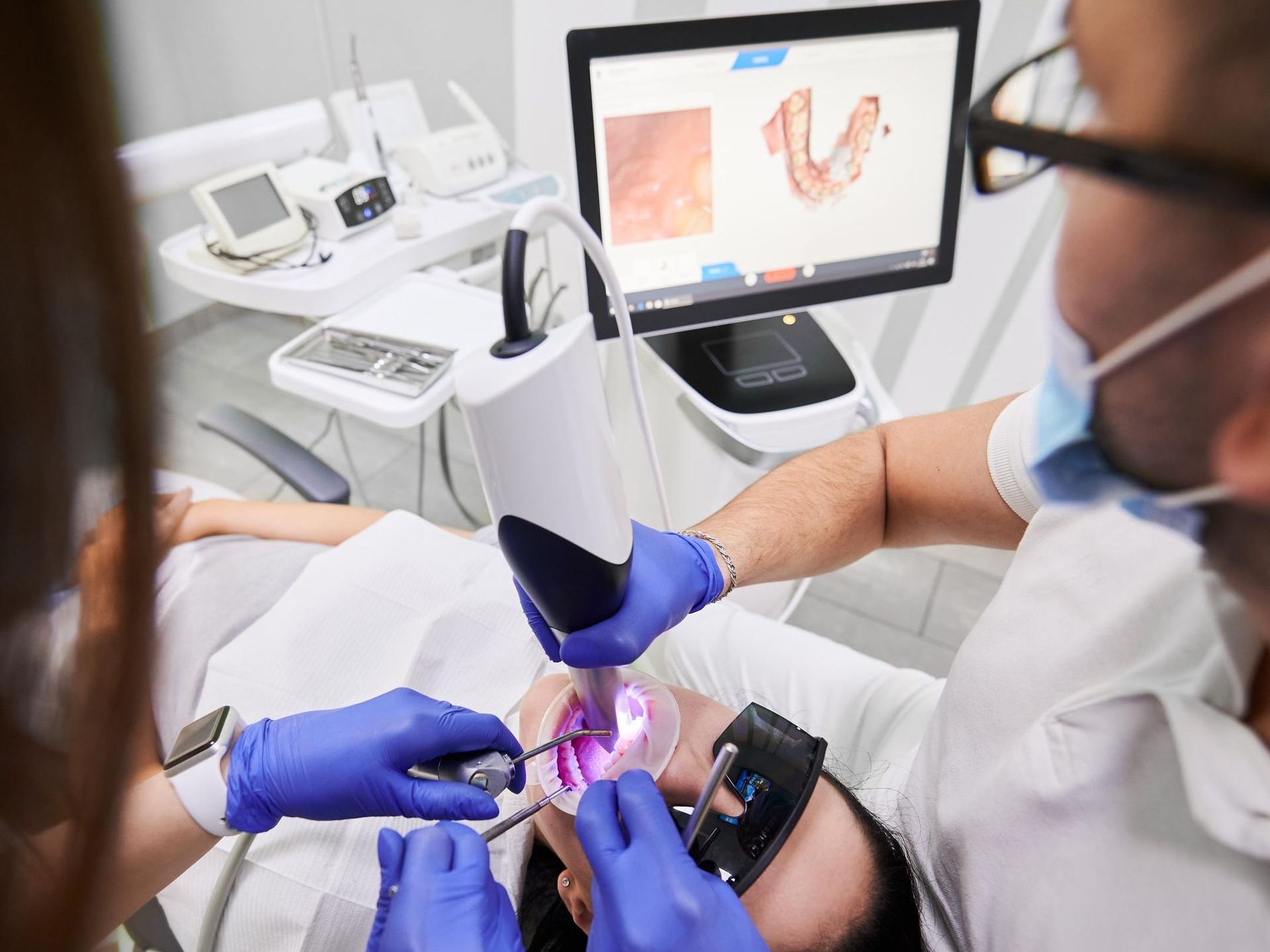 A young boy is getting his teeth examined by a dentist.