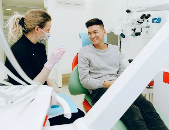 A young boy is getting his teeth examined by a dentist.