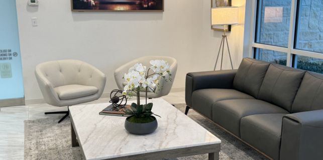 A living room with a couch , chairs , and a coffee table.