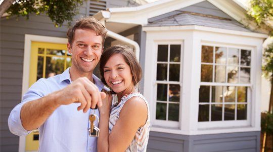 Buy a Home — Couple with Keys Standing Outside New Home in Louisiana